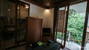 a living room with a couch and a large window at Baruna Sari Villa yoga and reatret view jungle in Ubud