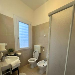 a bathroom with a toilet and a sink and a window at Hotel Furga B&B in Cervia +15 photos
