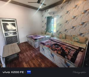 a room with two beds and a stone wall at Hotel karishna palace in Rīngas
