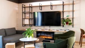 a living room with a tv and a fireplace at Campanile NATURE - Compiegne in Compiègne
