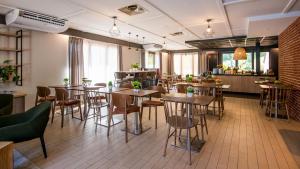 a restaurant with tables and chairs in a room at Campanile NATURE - Compiegne in Compiègne