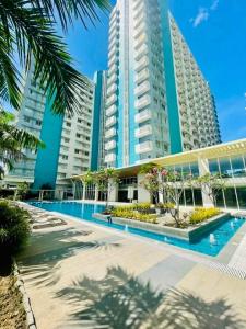 a large building with a swimming pool in front of it at Ona's Condo in Bacolod