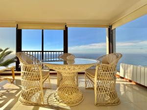 a table and chairs on a balcony with the ocean at Esperanza in Tacoronte