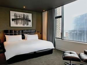 a bedroom with a large bed and a large window at Century City Hotel Urban Square in Cape Town