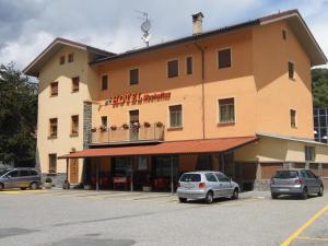un grande edificio con auto parcheggiate in un parcheggio di Hotel Mochettaz ad Aosta