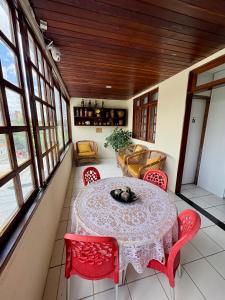 a dining room with a table and red chairs at Lira Hostel in Caruaru