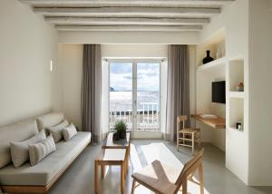 a living room with a couch and a large window at The Coast Bill&Coo-The Leading Hotels of the World in Agios Ioannis Mykonos