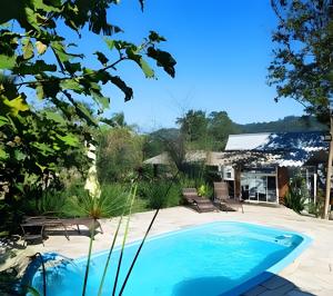 a swimming pool in the yard of a house at Chalé Primavera Rosa com piscina in Penha