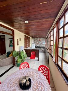 a dining room with a table and red chairs at Lira Hostel in Caruaru