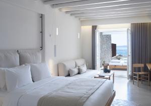 a bedroom with a large bed and a living room at The Coast Bill&Coo-The Leading Hotels of the World in Agios Ioannis Mykonos +60 photos