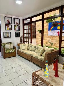 a living room with a couch and a large window at Lira Hostel in Caruaru