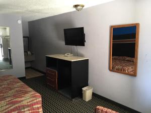 a hotel room with a bed and a mirror at Fulton Inn in Atlanta