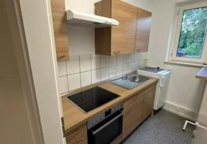 a small kitchen with a sink and a stove at Pension De Lux Augsburg in Augsburg