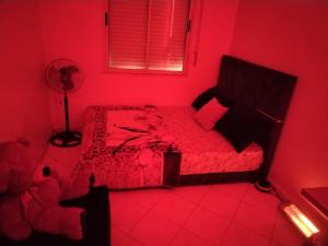 a red bedroom with a bed in a room with a fan at chambre pour 2 sidi maarouf in Casablanca