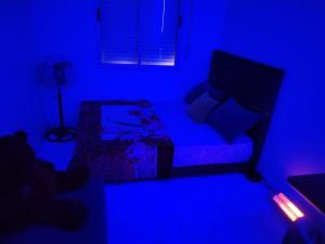 a blue room with a couch and a lamp at chambre pour 2 sidi maarouf in Casablanca