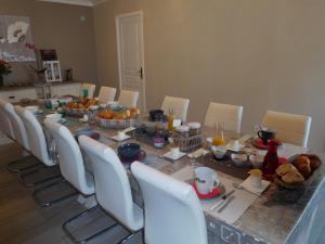 - une salle à manger avec une table, des chaises et de la nourriture dans l'établissement Le Vallon de Paray, à Paray-le-Monial