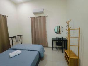 a bedroom with a bed and a desk with a mirror at Seri Mersing Villa A in Mersing +39 photos
