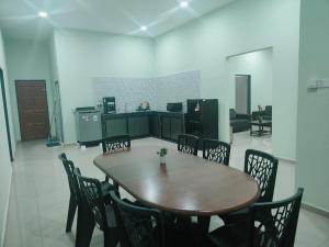 a table and chairs in a room with a kitchen at Seri Mersing Villa A in Mersing
