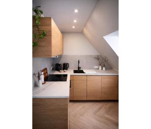 a kitchen with white counters and wooden cabinets at Top bewertete 2-Zimmer-Wohnung mit sehr gut ausgestatteter Küche, Netflix und gemütlichem Schlafzimmer in Hildesheim in Hildesheim