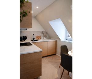 a kitchen with wooden cabinets and a window at Top bewertete 2-Zimmer-Wohnung mit sehr gut ausgestatteter Küche, Netflix und gemütlichem Schlafzimmer in Hildesheim in Hildesheim