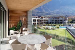 a dining room with a table and chairs on a balcony at Lago Dorato Luxury Apartments - Lake Como View in Colico