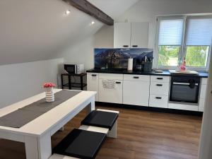 a kitchen with white cabinets and a white table at Vilseck Stay in Vilseck