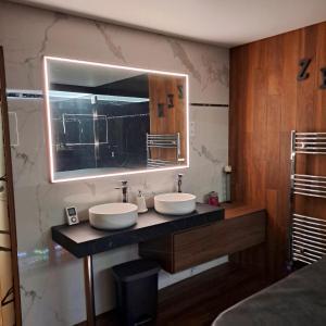 a bathroom with two sinks and a mirror at LES CLEFS DU PARADIS avec SPA in Montferrand-le-Château +20 photos
