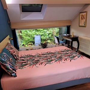 a bedroom with a bed and a desk and a window at LES CLEFS DU PARADIS avec SPA in Montferrand-le-Château