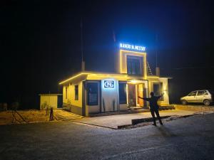 a man standing in front of a building at night at NANGRI Homestay in Pynursla