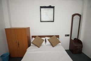 a bedroom with a bed with pillows and a mirror at NANGRI Homestay in Pynursla +11 photos