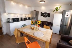 a kitchen with a wooden table and a kitchen with a refrigerator at Royal Chambers Liverpool in Liverpool