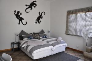 a bedroom with a bed with black cats on the wall at Outeniqua Guest Farm in Okahandja +28 photos