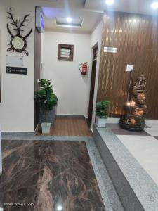 a lobby with a clock on the wall and plants at Hotel Heaven Blu in Hodal