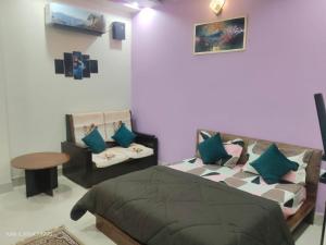a bedroom with a bed and a couch and a table at Hotel Heaven Blu in Hodal