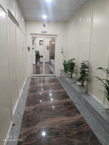an office hallway with a wooden floor and plants at Hotel Heaven Blu in Hodal +14 photos