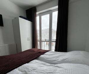 a bedroom with a bed and a large window at Tribu Bakuriani in Bakuriani