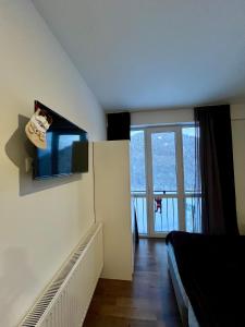 a room with a tv on the wall next to a bed at Tribu Bakuriani in Bakuriani +4 photos