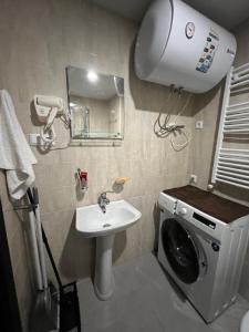 a bathroom with a washing machine and a sink at Tribu Bakuriani in Bakuriani