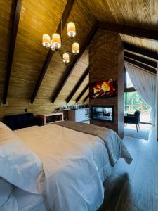 a bedroom with a large white bed and a fireplace at Pousada Duas Marias in Nova Veneza