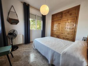 a bedroom with a white bed and a wooden door at Villa Xaloc piscine privée in Les tres Cales +13 photos