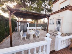 a patio with a table and chairs and a gazebo at Villa Xaloc piscine privée in Les tres Cales