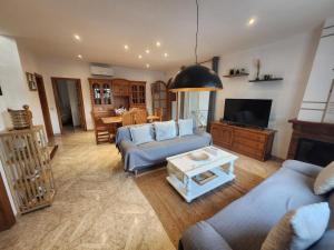 a living room with two couches and a tv at Villa Xaloc piscine privée in Les tres Cales