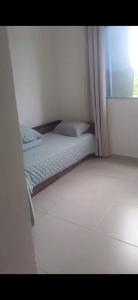 a small bed in a room with a window at Outeiro in Belém
