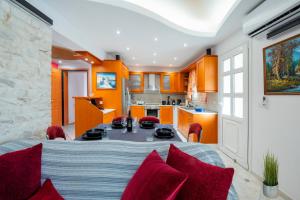 a kitchen and dining room with a table and red chairs at Golden Grove in Afantou
