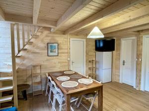a wooden room with a table and a staircase at Chalet neuf proche des stations de ski in Saint-Pons