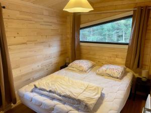 a bedroom with a bed in a log cabin at Chalet neuf proche des stations de ski in Saint-Pons