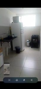 a small kitchen with a refrigerator and a table at Outeiro in Belém
