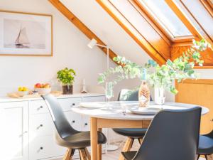 a dining room with a table and chairs at Huus Binnensee OG2 - Dachwohnung mit Wasserblick - Lesesessel & WLAN - Für Paare - Ruhige Lage - Südstrand 5 Min mit Rad in Fehmarn