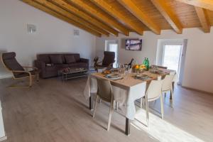 a dining room with a table and a couch at Villa Perla del Lago in Vercana