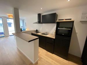 a kitchen with a sink and a stove top oven at Studio Dour avec terrasse à proximité des plages in Étel